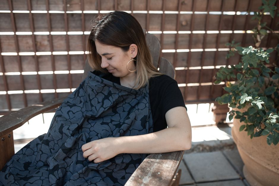 Nursing cover draped over mother and child providing privacy