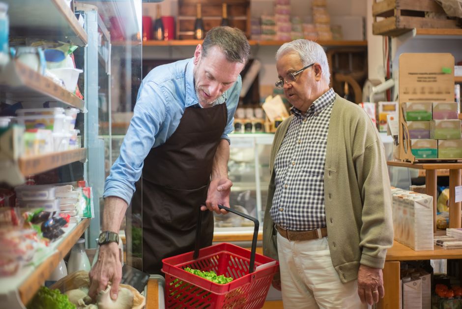 A grocery store staff member assisting a customer with their shopping