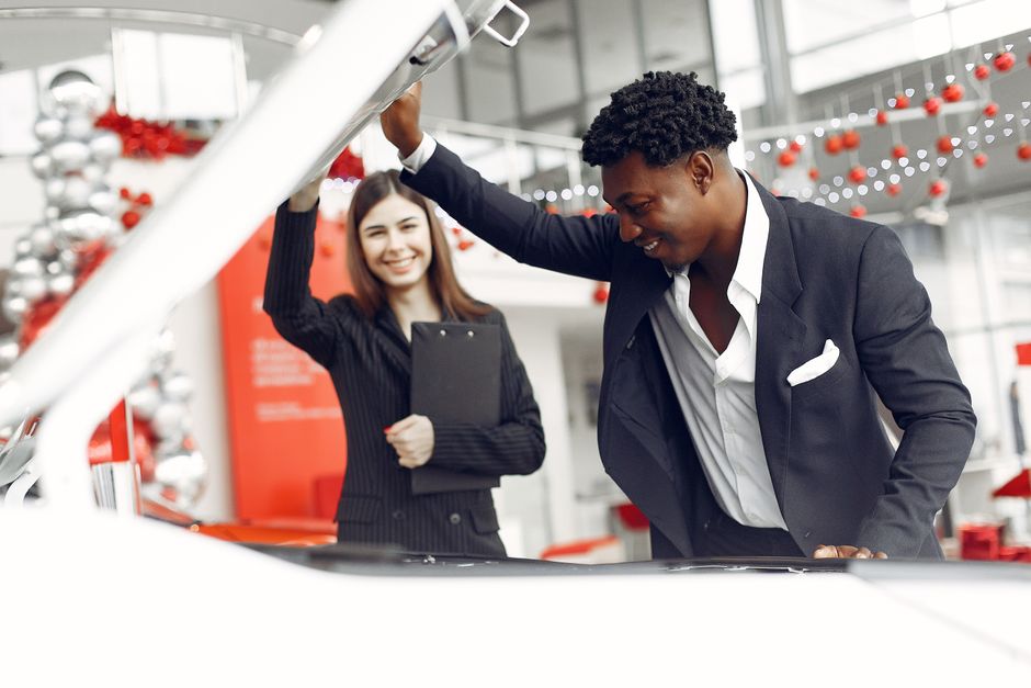 Auto body shop technicians with repaired vehicles