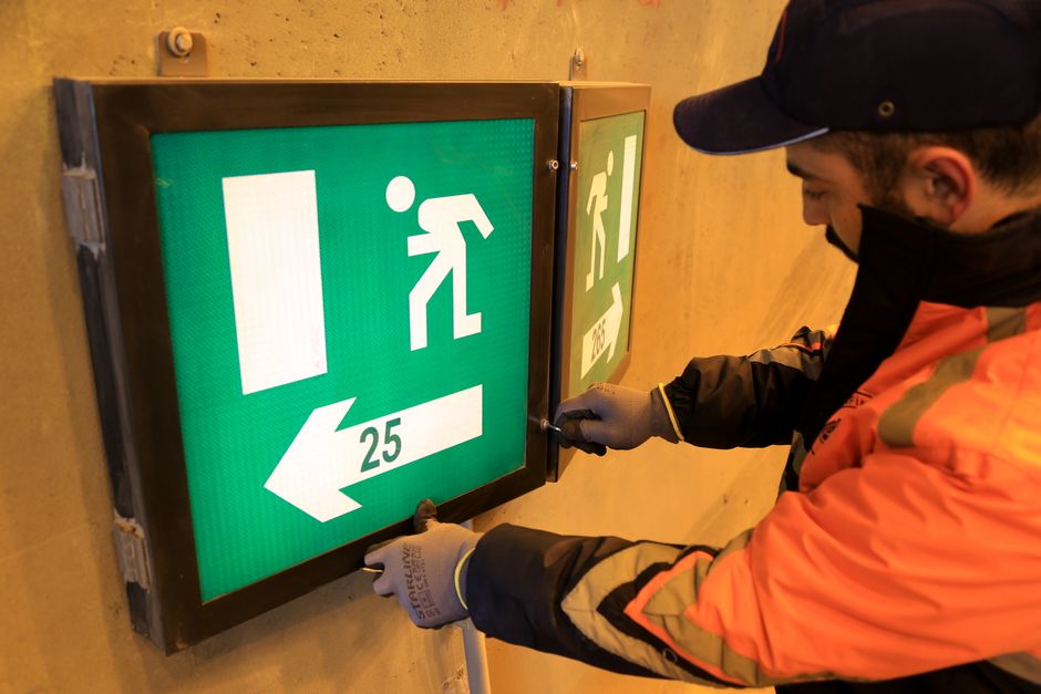Technician repairing emergency lighting fixtures