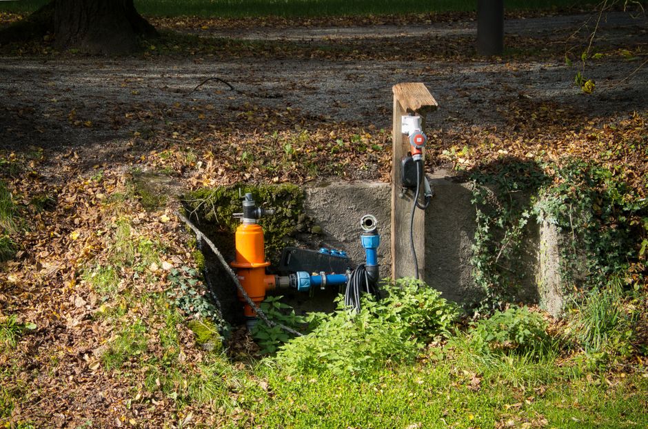 Technician setting up an irrigation system in a landscaped yard