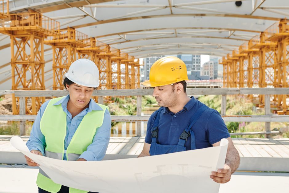 Project manager examining blueprints at a building site