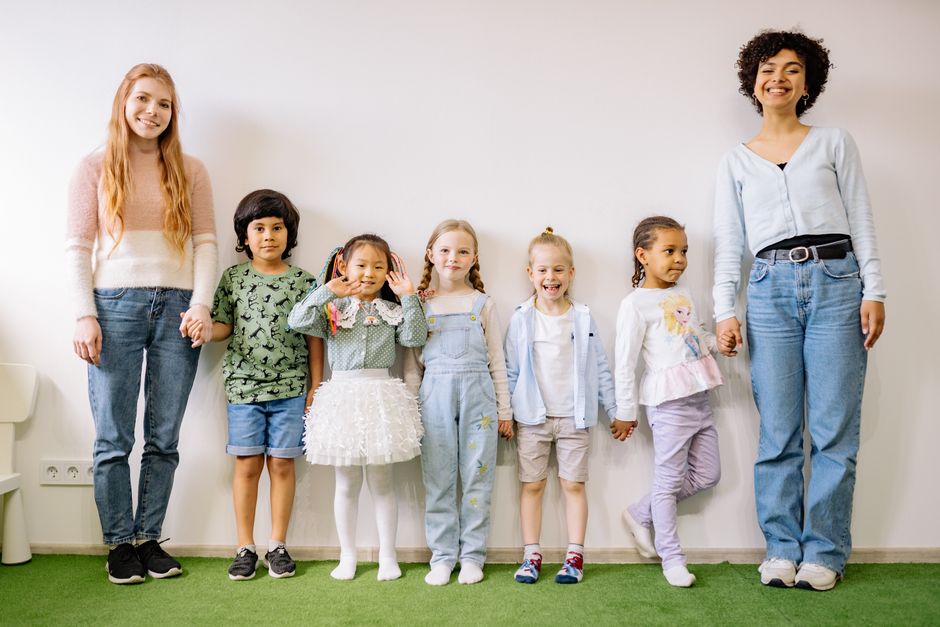 Group of happy preschool children playing outdoors together