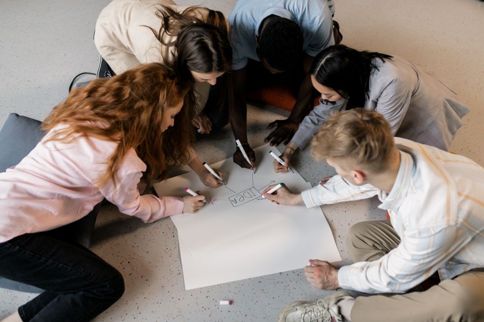 A diverse group of creators brainstorming game ideas on a whiteboard