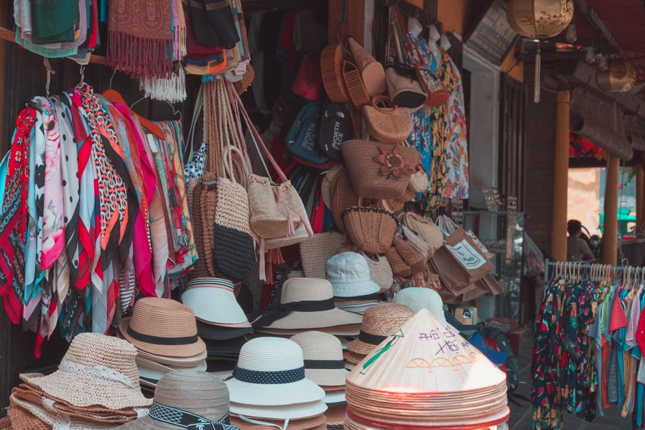 Fashion accessories such as bags, scarves, and hats displayed on table