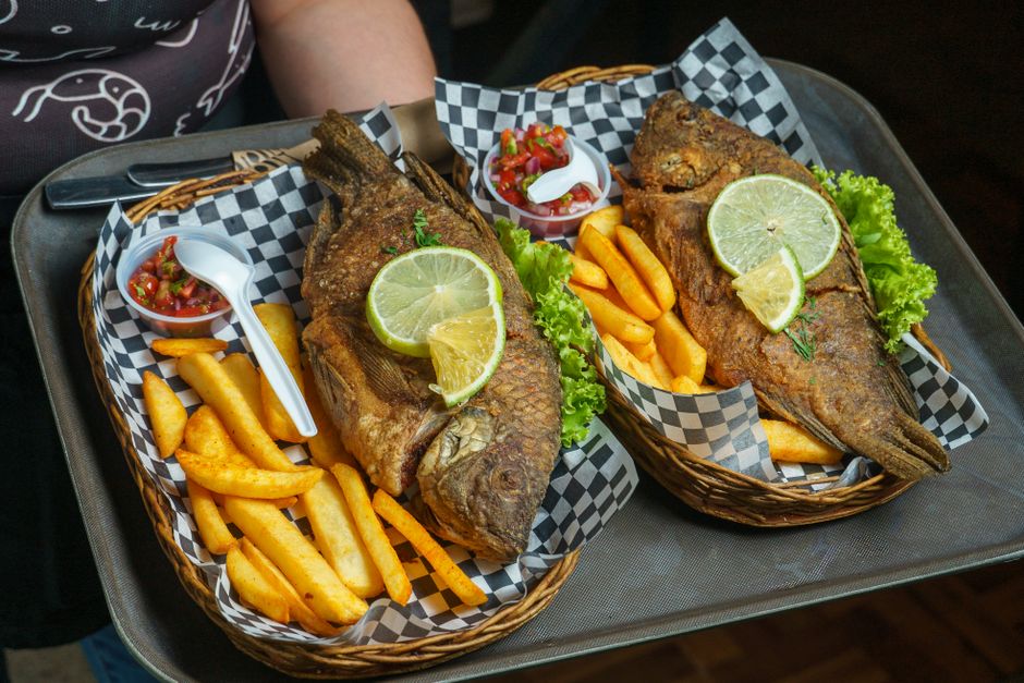 Fried whole tilapia with fresh salad, typically served in Ghana