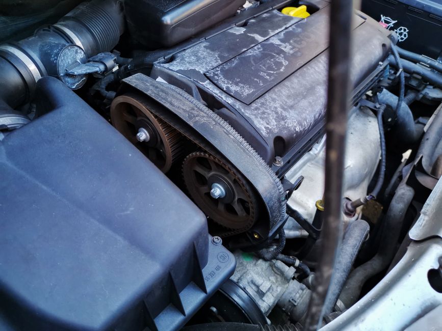 Mechanic inspecting car brakes and timing belt