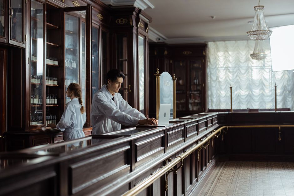Pharmacists consulting with customers at a pharmacy counter