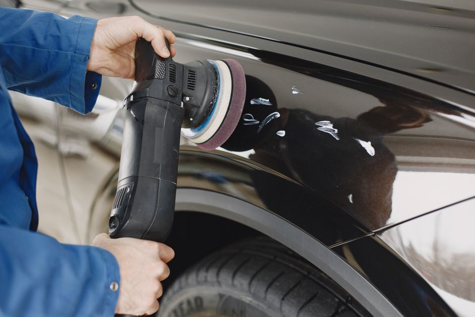 Technician repairing dents on a car body panel