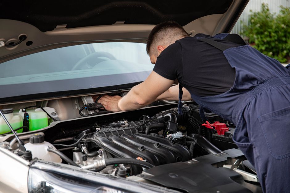Auto mechanic working on an engine inside the workshop