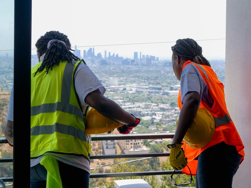Support workers in discussion overlooking Los Angeles skyline