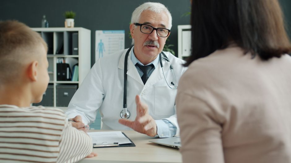 A doctor providing care to a family in a clinical setting