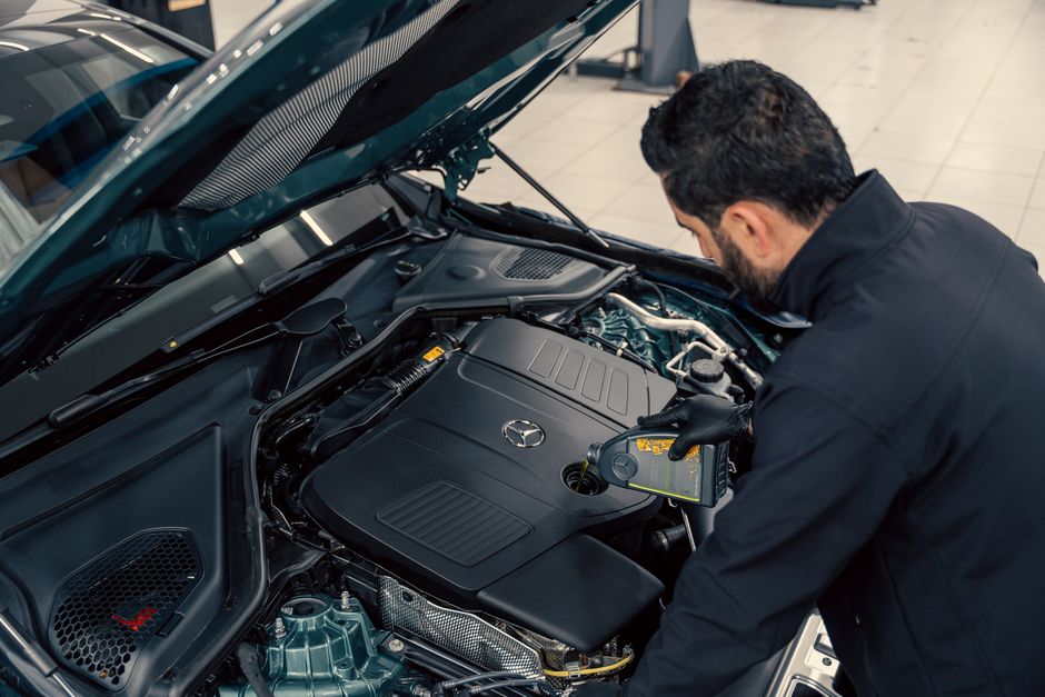Technician performing oil and fluid maintenance