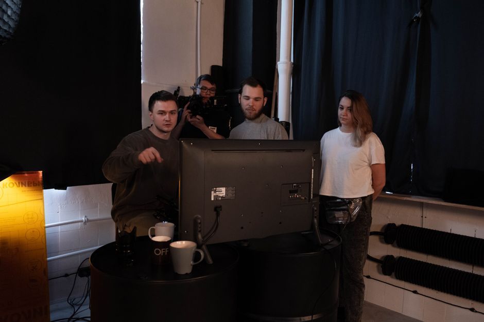 Media project management studio with people collaborating and screens