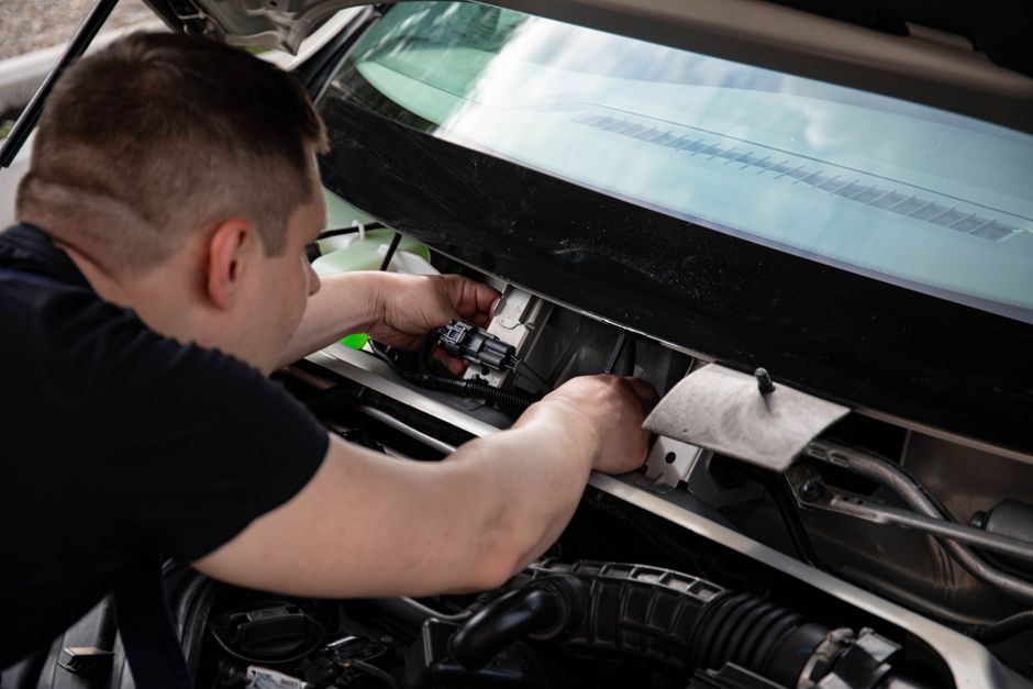 Specialist using tools to remove dents from a car surface