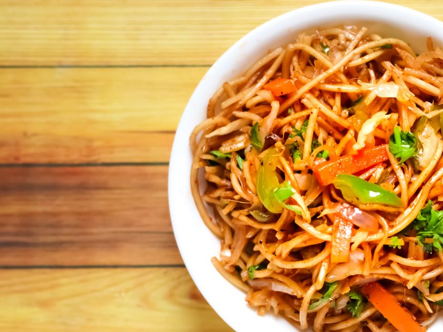 Vegetable lo mein with colorful vegetables on a rectangular plate