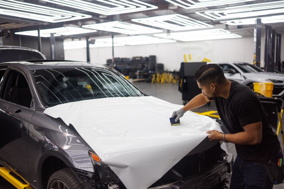 Technician performing auto detailing on car exterior