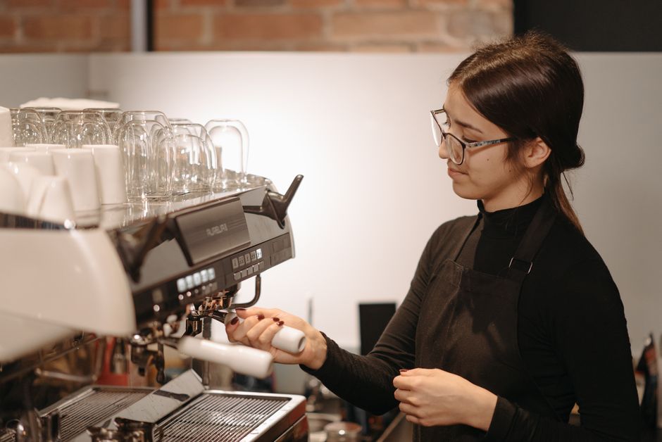 Barista preparing espresso drink behind the counter