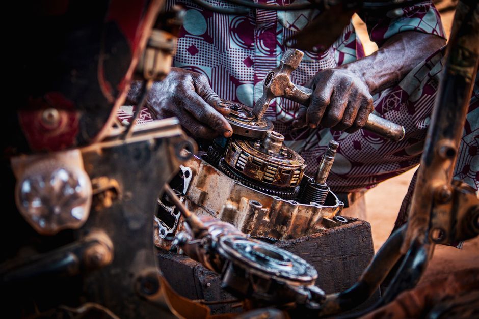 A specialist installs components on a replica Indian motorcycle chassis kit in a garage setting