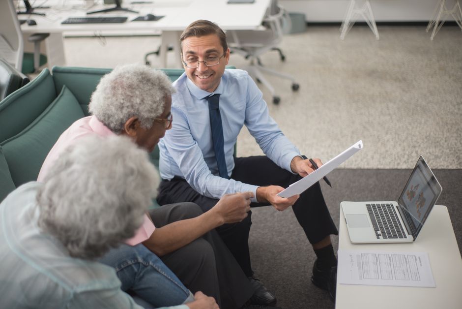 Senior couple reviewing paperwork with advisor