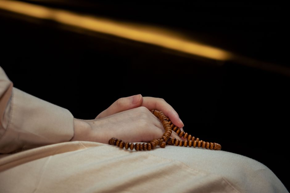 Person holding traditional Ifa beads during a sacred ritual