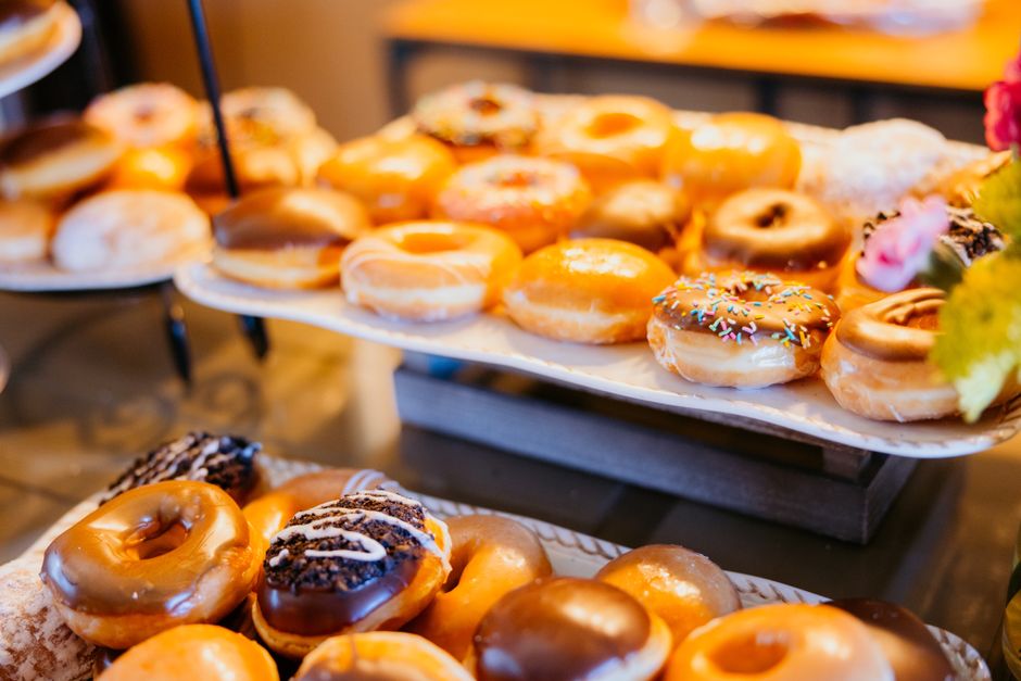 Freshly glazed donuts arranged in a bakery case