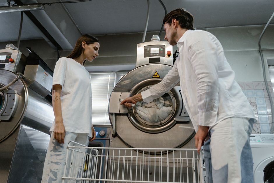 Friendly laundromat attendant helping customer