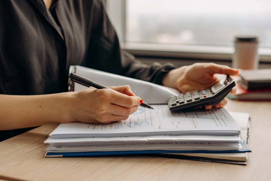 Attorney working at desk with documents and calculator