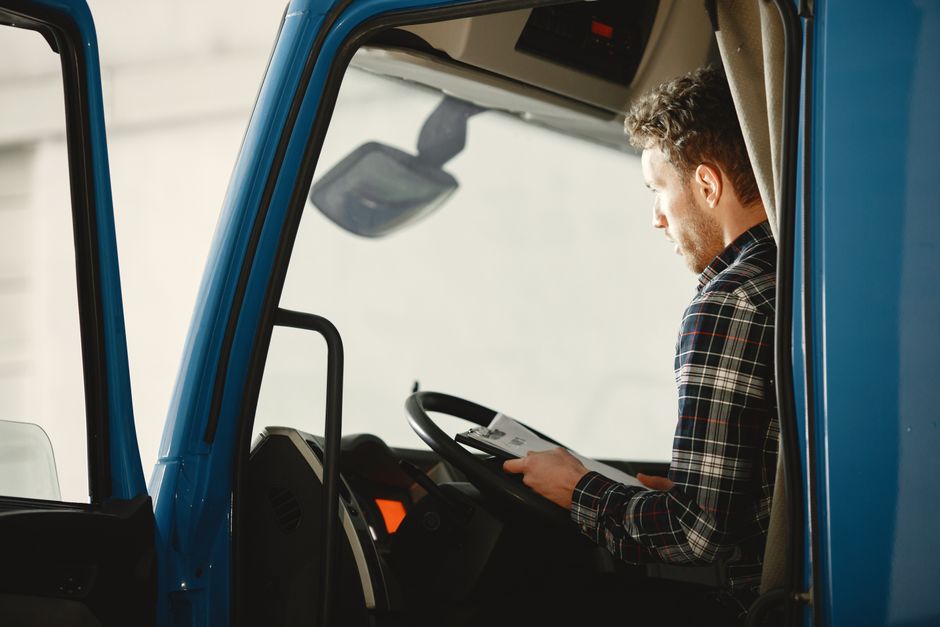 Professional truck driver sitting and reading a magazine at a rest stop