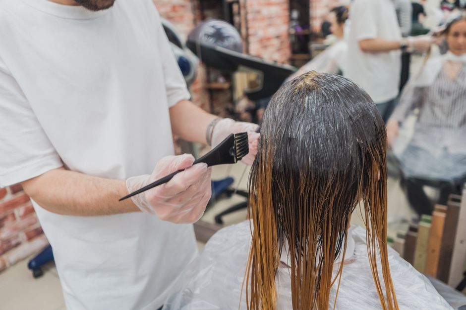 Colorist applying hair highlights at a salon