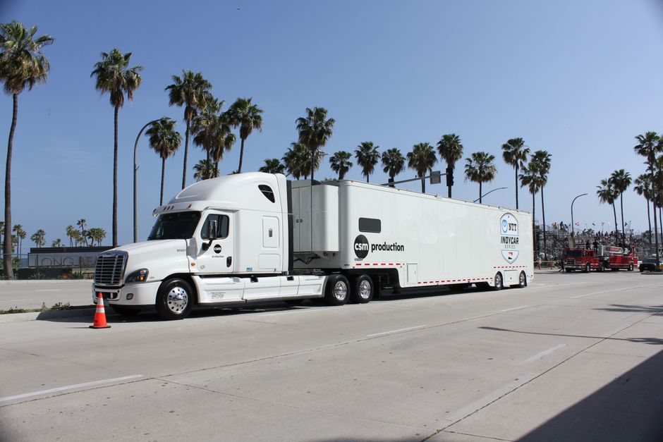 Film production trucks and trailers parked at a shooting location
