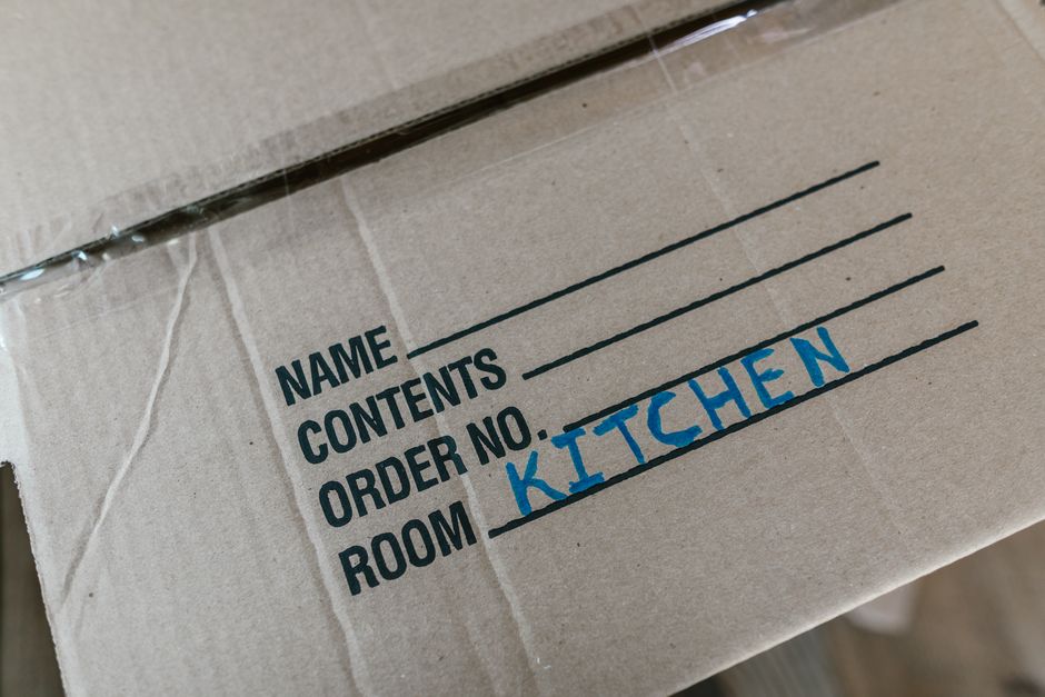 Close up of moving boxes labeled 'Kitchen' and 'Fragile'