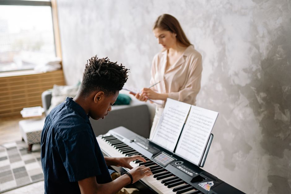Music instructor guiding a vocal student in a Los Angeles recording studio