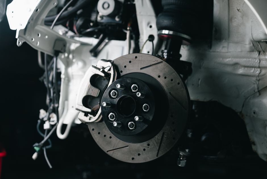 Mechanic repairing brake and suspension systems on a car