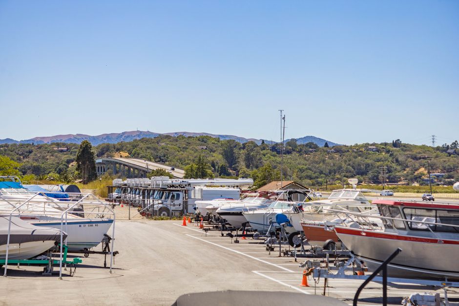 Large outdoor area with parked RVs, cars, and boats at a storage facility