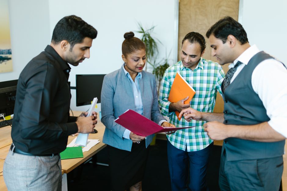 Project manager reviewing documents with a team in an office