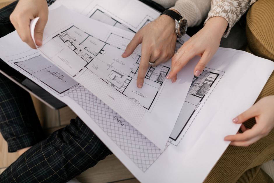 Hands reviewing construction plans for property improvements