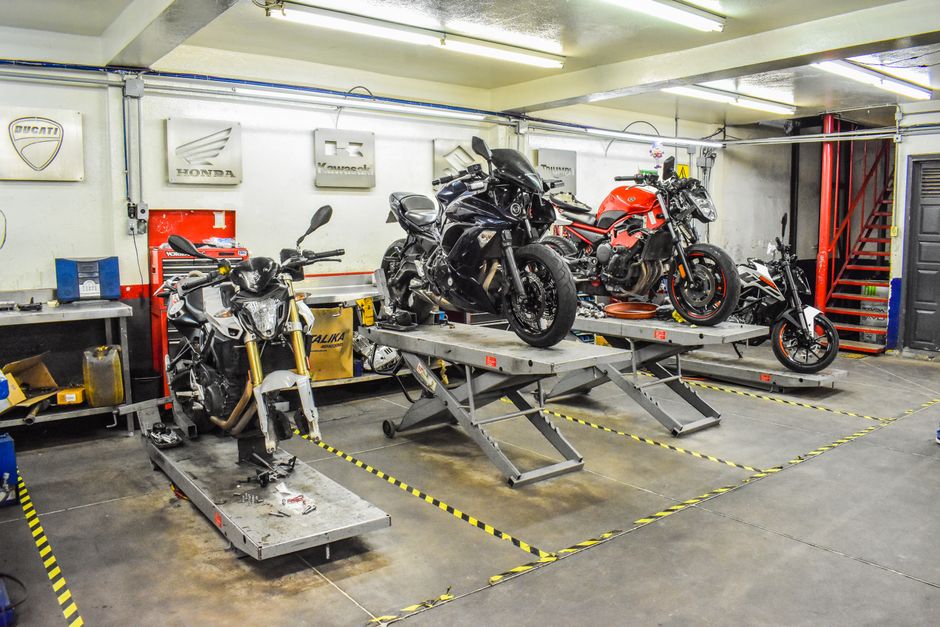 Professionals servicing motorcycles and ATVs in a garage
