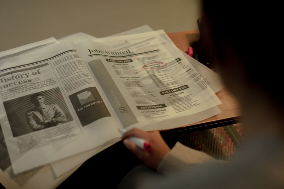 Person reading a print classified ads newspaper