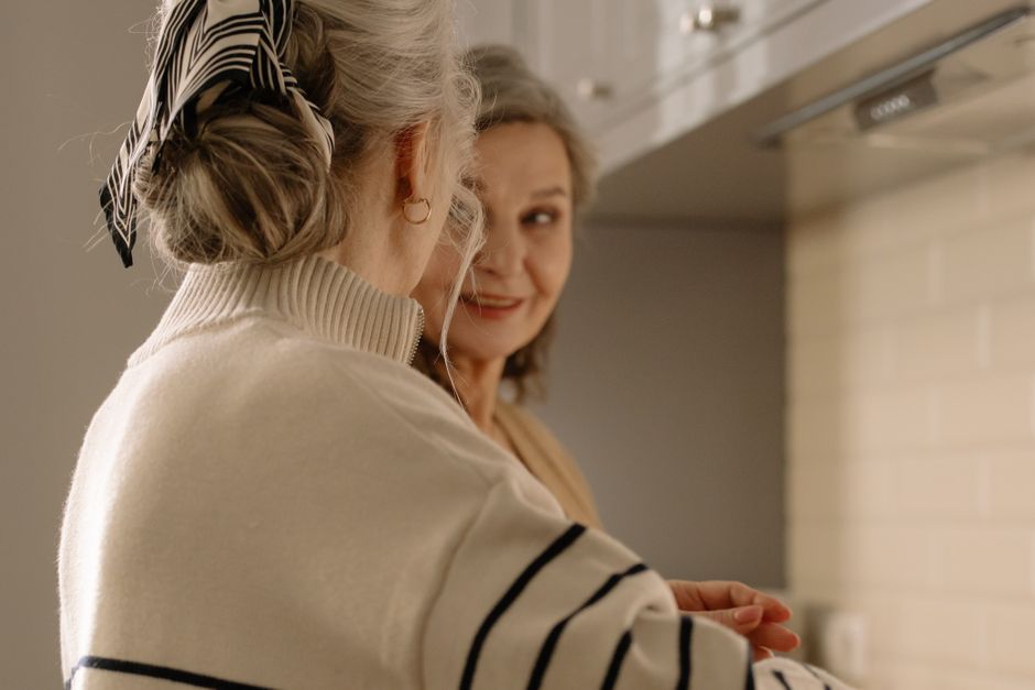 A senior woman enjoying conversation with a companion at her home