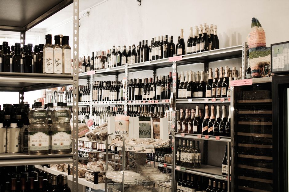 Staff member stocking liquor shelves in a store
