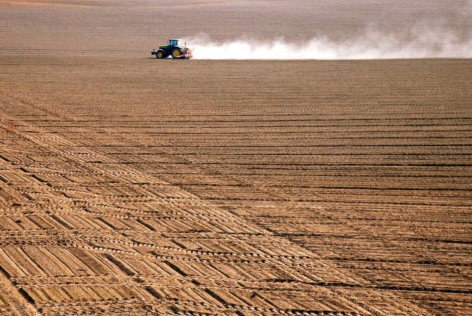 Tractor performing deep ripping in a farm field, improving soil structure