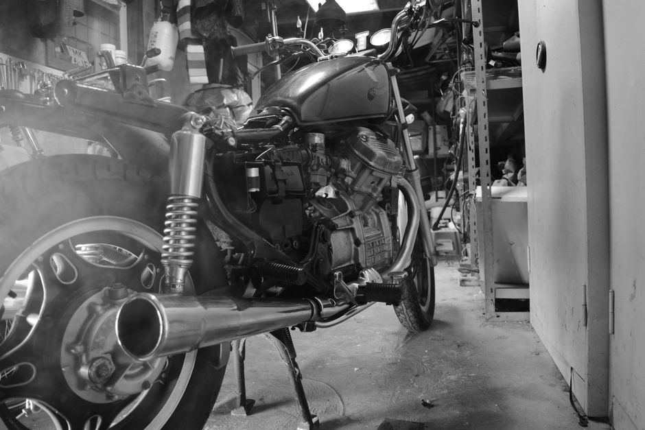 A builder inspects a restored Indian motorcycle inside a vintage workshop