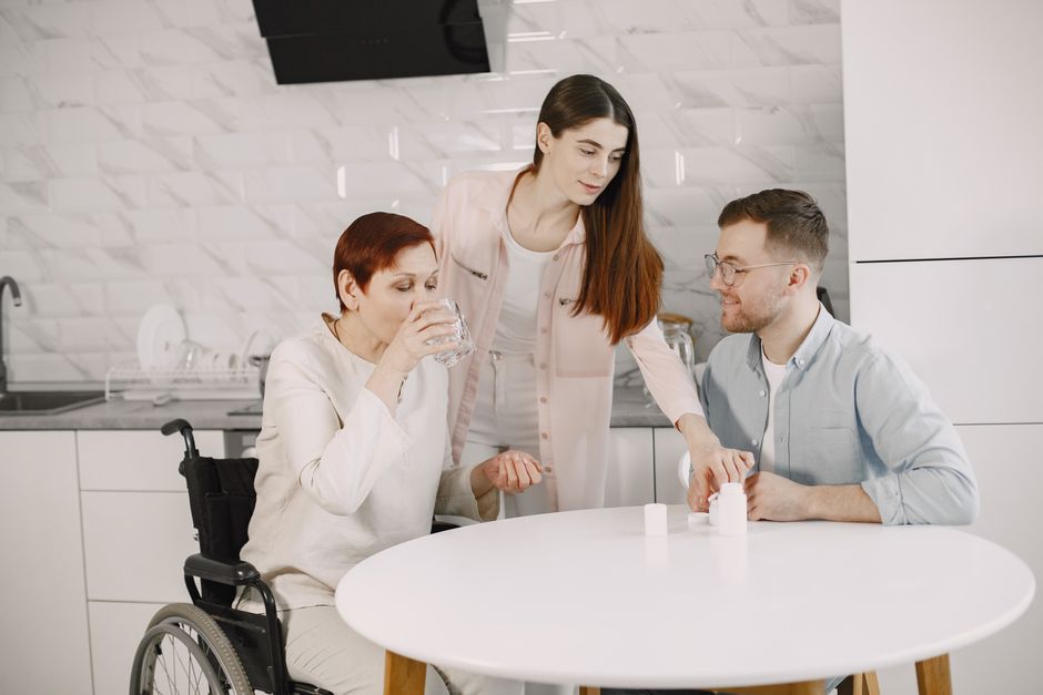 A caregiver helping an older adult get dressed and manage daily routines
