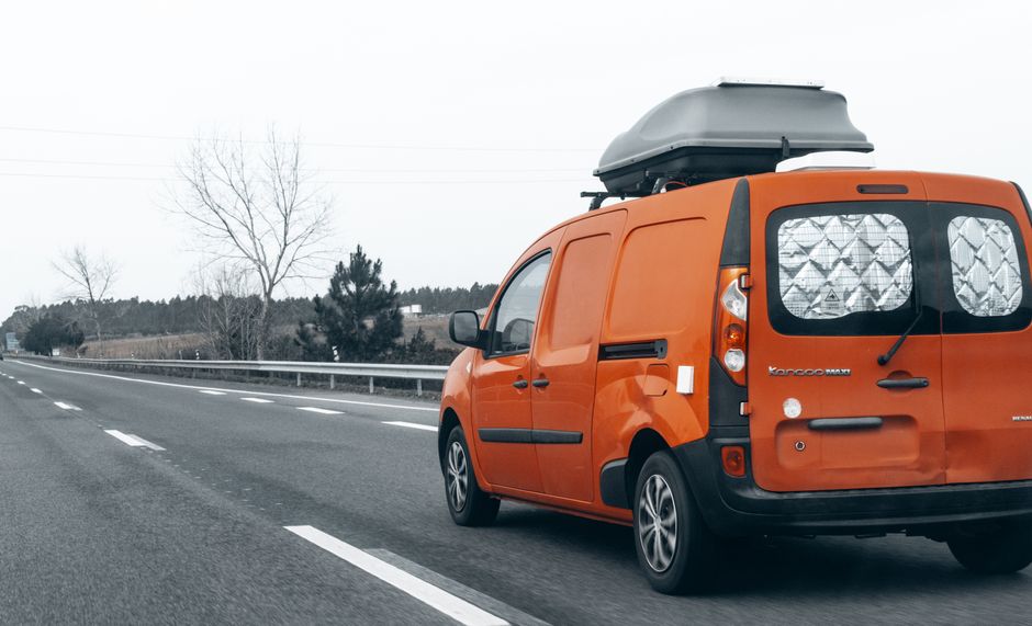 A cargo van driving on a highway during daylight