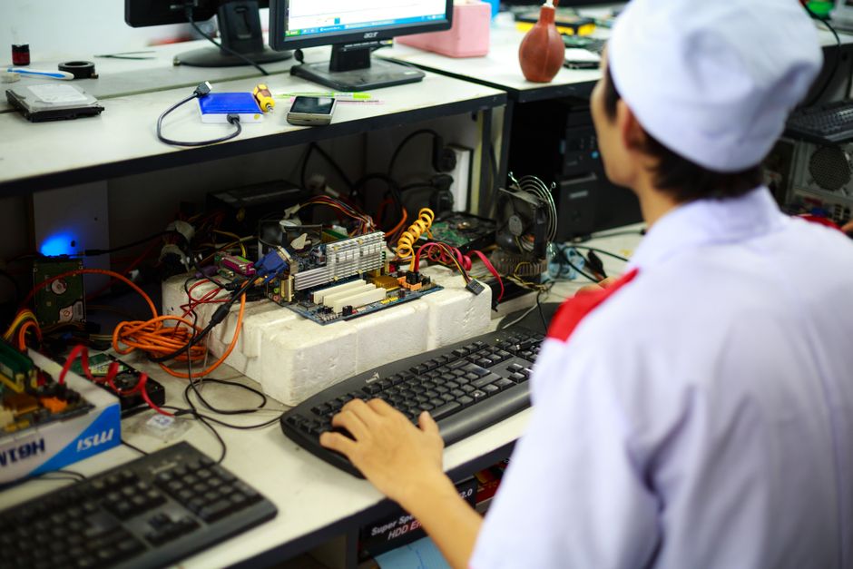 A technician working on a computer motherboard