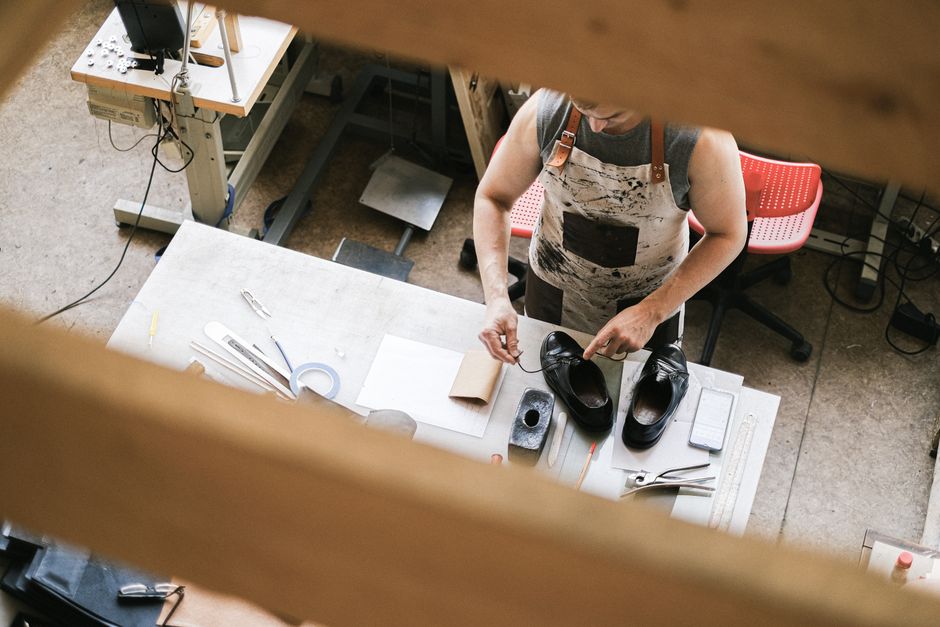 Artisan working with premium leather shoe materials