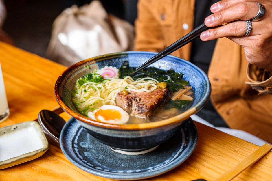 A bowl of Japanese ramen served with toppings on a restaurant table