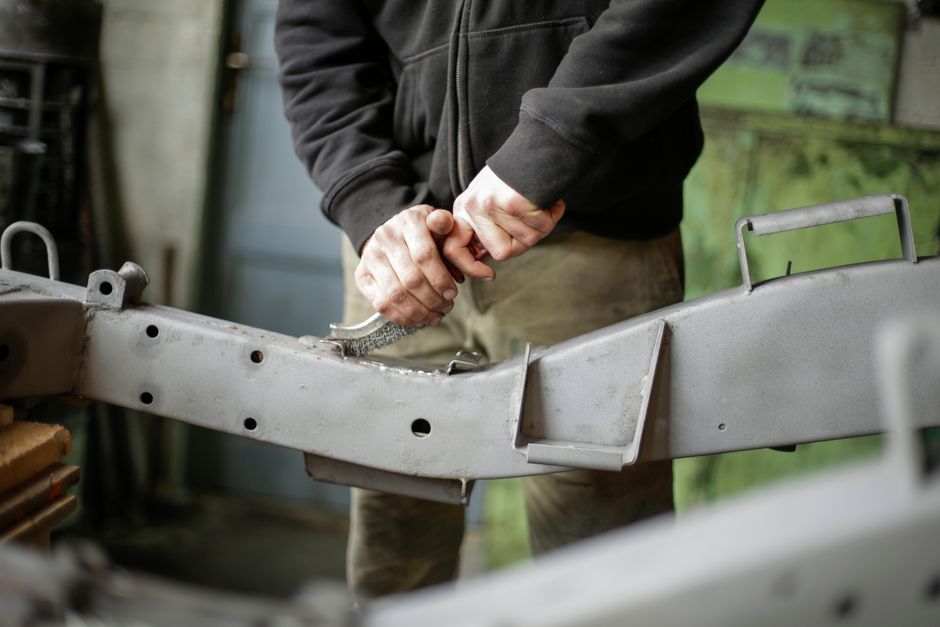 Technicians realigning a car frame in an auto body repair workshop