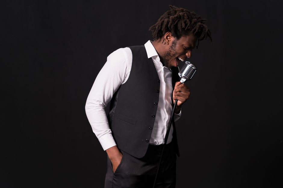 Singer performing a vocal audition in a professional studio environment